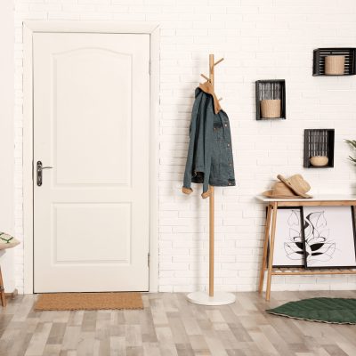 Stylish hallway interior with shoe storage bench, hanger stand and table