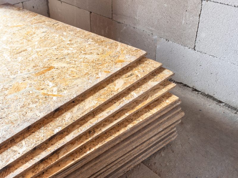 OSB slab building material made from reborn sawdust. They are stacked. Close-up.