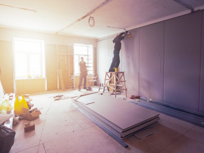 Workers are installing plasterboard (drywall) for gypsum walls in apartment is under construction, remodeling, renovation, extension, restoration and reconstruction